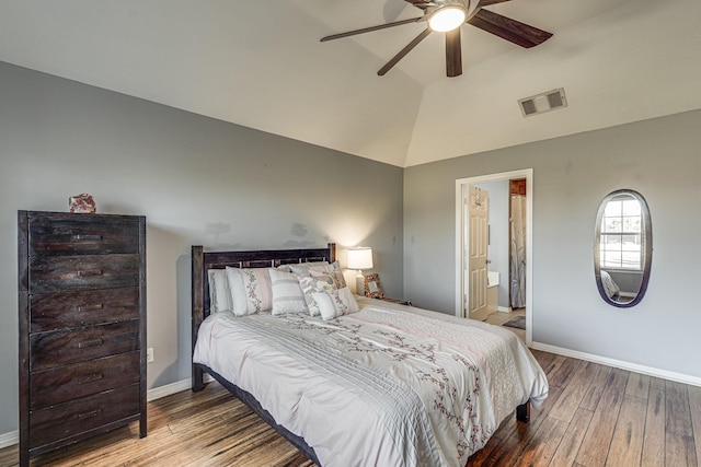 bedroom featuring hardwood / wood-style floors, ceiling fan, ensuite bath, and vaulted ceiling