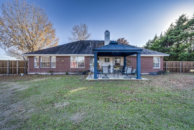 rear view of house featuring a yard and a patio area