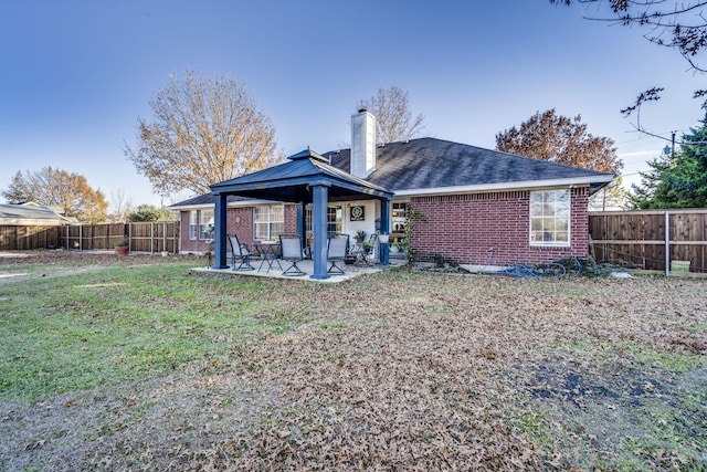 rear view of property with a patio area and a yard