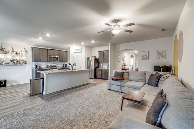 living room with ceiling fan and light hardwood / wood-style floors