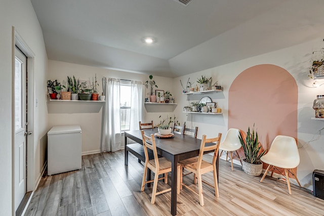 dining room featuring light hardwood / wood-style flooring and lofted ceiling