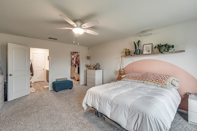 carpeted bedroom featuring ceiling fan, a spacious closet, and a closet