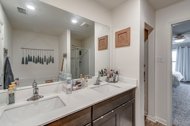 bathroom with ceiling fan, walk in shower, and vanity