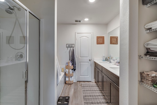 bathroom featuring hardwood / wood-style flooring, an enclosed shower, and vanity