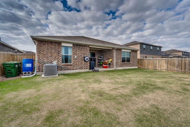 back of property featuring central AC unit and a yard