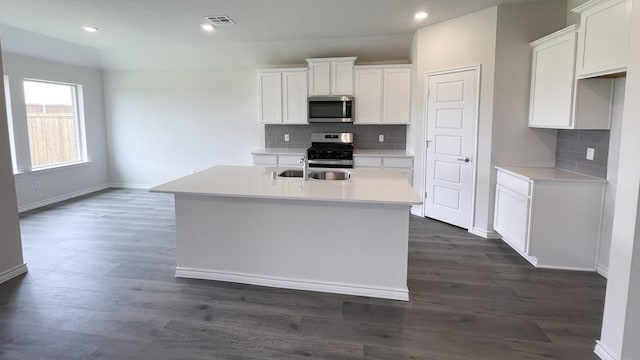 4224 Lucy Ln, Sherman, TX 75090 - kitchen with appliances with stainless steel finishes, baseboards, a kitchen island with sink, decorative backsplash, and white cabinets
