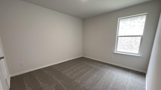 4224 Lucy Ln, Sherman, TX 75090 - empty room featuring healthy amount of natural light, dark colored carpet, and baseboards