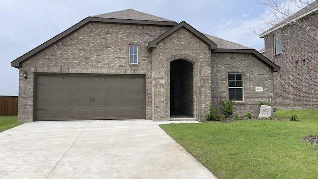 4224 Lucy Ln, Sherman, TX 75090 - french provincial home featuring brick siding, concrete driveway, a front lawn, and a garage