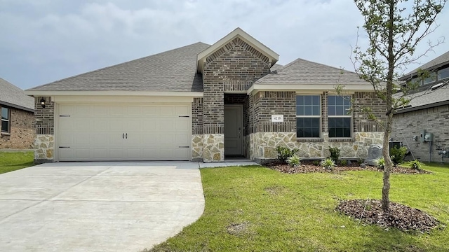 4219 Sky Dr, Sherman, TX 75090 - view of front of property featuring stone siding, an attached garage, driveway, a front lawn, and roof with shingles