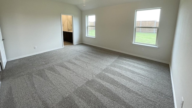 4219 Sky Dr, Sherman, TX 75090 - unfurnished bedroom featuring baseboards, carpet, vaulted ceiling, and connected bathroom