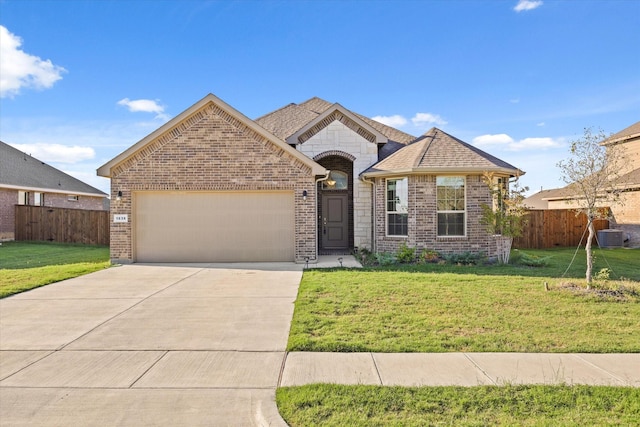 view of front of home with cooling unit, a garage, and a front yard