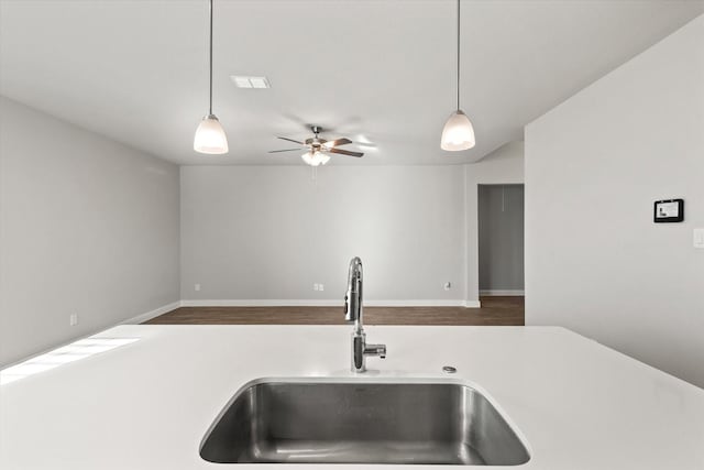 kitchen featuring ceiling fan, sink, and decorative light fixtures