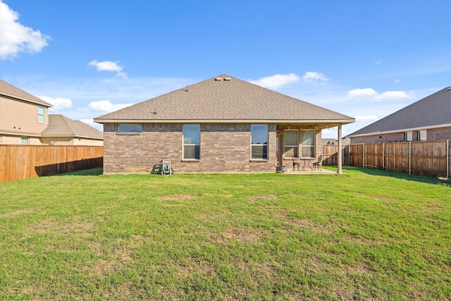 back of property with a yard and a patio