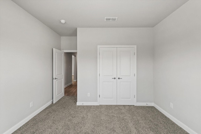 unfurnished bedroom featuring carpet flooring and a closet