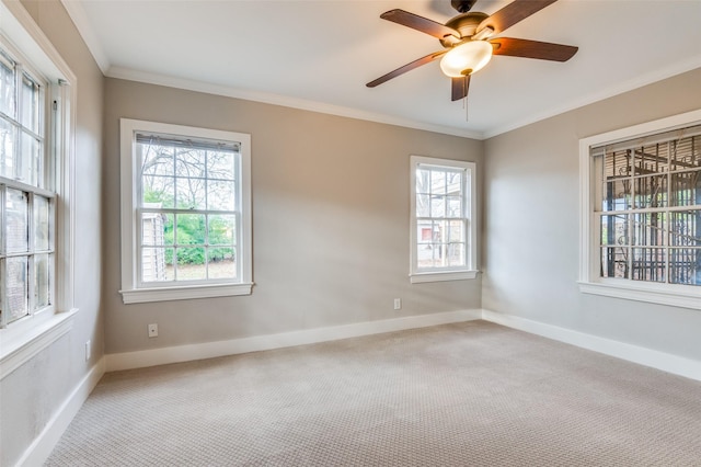 empty room with ceiling fan, light colored carpet, and ornamental molding