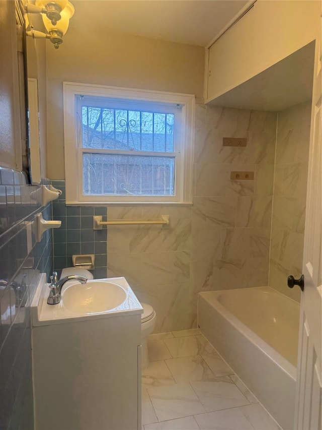 bathroom with tile walls, toilet, a bath, and vanity