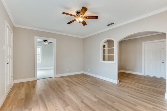 empty room featuring ceiling fan, crown molding, and light wood-type flooring