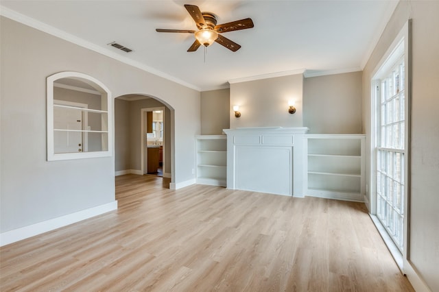 unfurnished living room featuring ceiling fan, ornamental molding, and light wood-type flooring