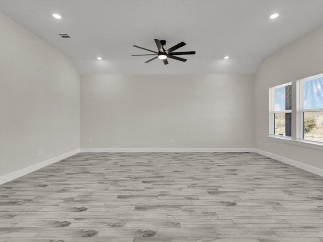 empty room featuring ceiling fan, lofted ceiling, and light hardwood / wood-style floors