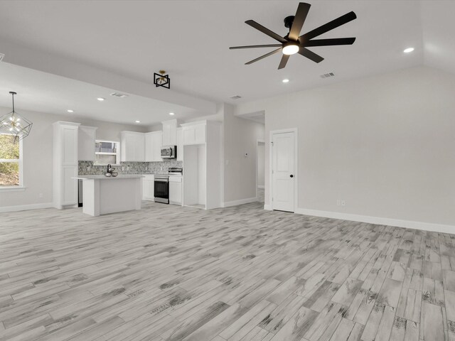 unfurnished living room featuring lofted ceiling, light hardwood / wood-style floors, and ceiling fan