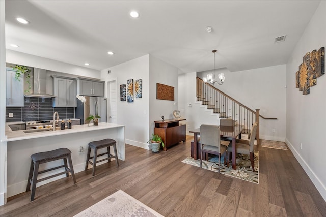 dining space featuring a chandelier, dark hardwood / wood-style flooring, and sink