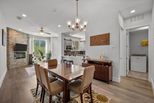 dining space featuring light hardwood / wood-style flooring and ceiling fan with notable chandelier