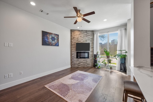 living room with ceiling fan, dark hardwood / wood-style flooring, and a fireplace