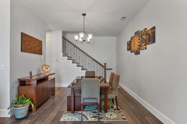 dining area featuring dark hardwood / wood-style floors and an inviting chandelier