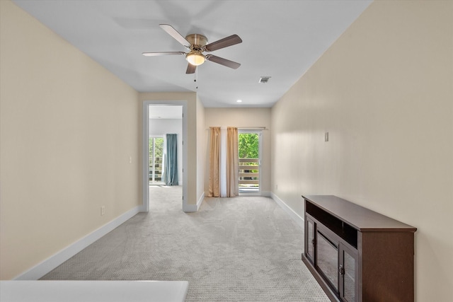 unfurnished room with ceiling fan and light carpet