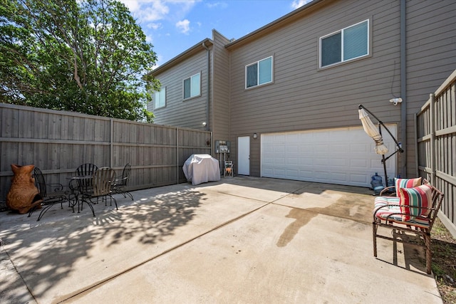 back of property with a garage and a patio area