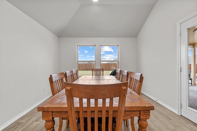 dining area featuring light hardwood / wood-style floors and vaulted ceiling