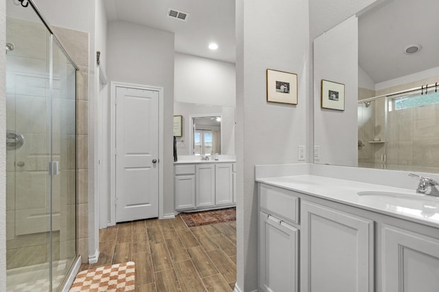 bathroom featuring a shower with door, vanity, and lofted ceiling