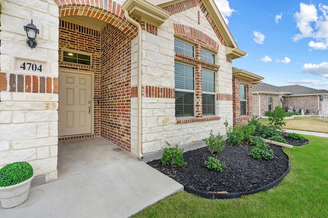 view of exterior entry featuring a yard