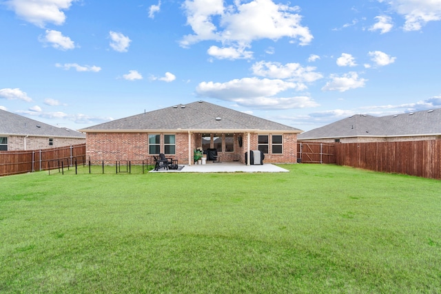 back of property with a lawn and a patio area