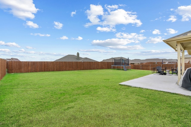 view of yard featuring a trampoline and a patio area