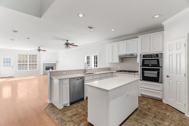 kitchen featuring sink, stainless steel appliances, white cabinets, and a kitchen island