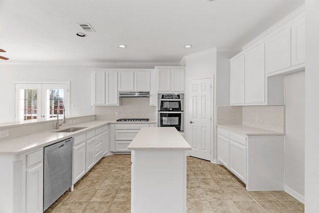 kitchen with sink, stainless steel appliances, white cabinetry, and a kitchen island