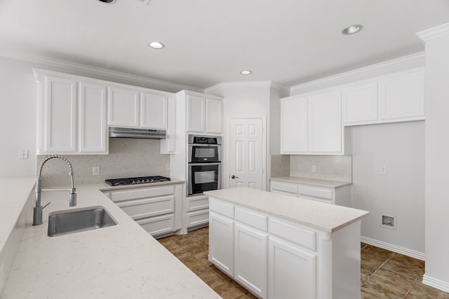 kitchen featuring appliances with stainless steel finishes, light stone counters, white cabinets, backsplash, and sink