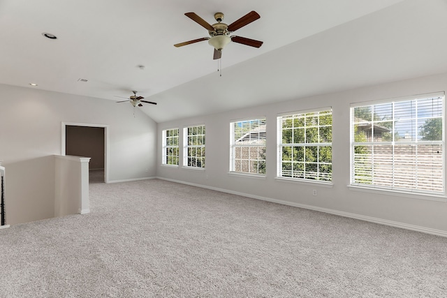 spare room with ceiling fan, vaulted ceiling, and light colored carpet