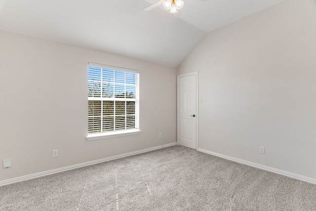 empty room with ceiling fan, vaulted ceiling, and carpet flooring