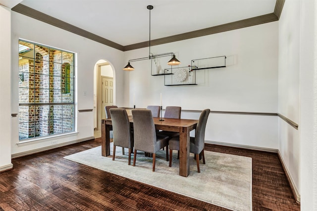 dining space with dark wood-type flooring and crown molding