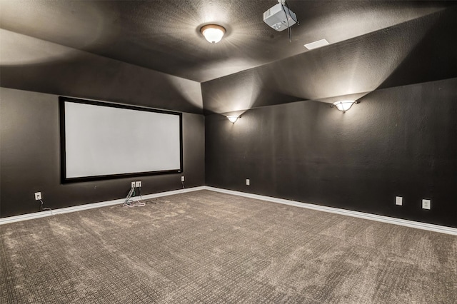 home theater featuring lofted ceiling, carpet floors, and a textured ceiling