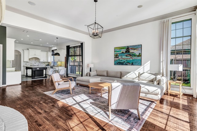 living room featuring ornamental molding, wood-type flooring, and a notable chandelier