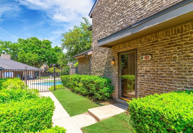 property entrance featuring a fenced in pool