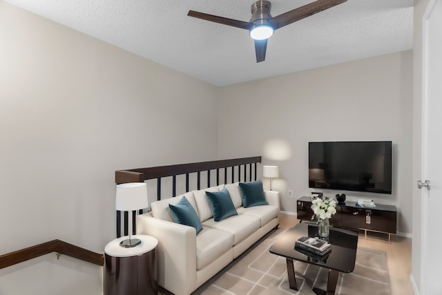 living room with ceiling fan and a textured ceiling