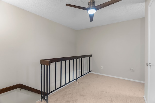 stairway with ceiling fan, carpet floors, and a textured ceiling