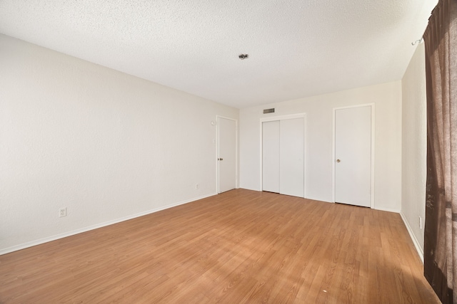 unfurnished bedroom with a textured ceiling and hardwood / wood-style flooring