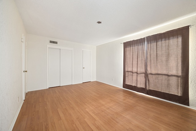 unfurnished bedroom featuring a textured ceiling and hardwood / wood-style flooring