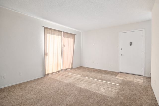 carpeted empty room featuring a textured ceiling