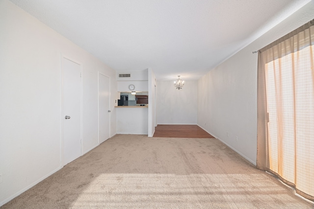 interior space featuring a chandelier and light carpet